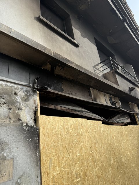 Ouverture du commerce sinistré fermée par un panneau de bois après incendie à Échirolles